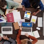 Equipe diversa trabalhando em uma estratégia de marketing digital com laptops e tablets sobre a mesa
