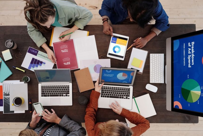 Equipe diversa trabalhando em uma estratégia de marketing digital com laptops e tablets sobre a mesa