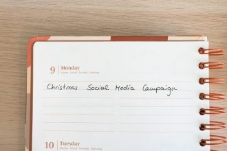 Página de um planejador com uma anotação sobre campanha de mídia social de Natal, ao lado de um teclado.