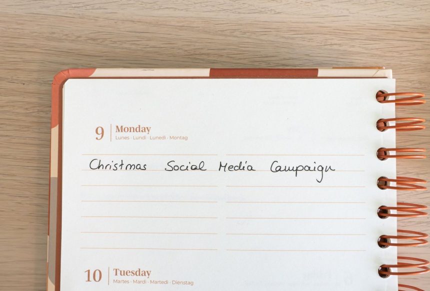 Página de um planejador com uma anotação sobre campanha de mídia social de Natal, ao lado de um teclado.