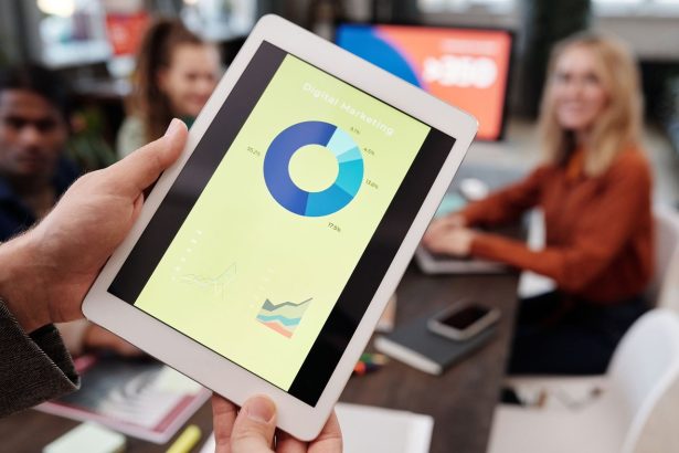 Equipe de profissionais de negócios analisa estatísticas de marketing digital em um tablet durante uma reunião.